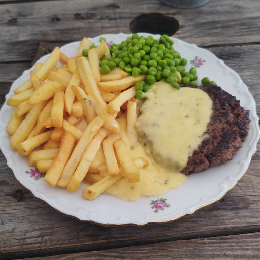 Herregårdsbøf med brasede kartofler, bearnaisesauce og grønærter.